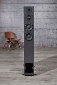 a tall speaker sitting on top of a wooden floor