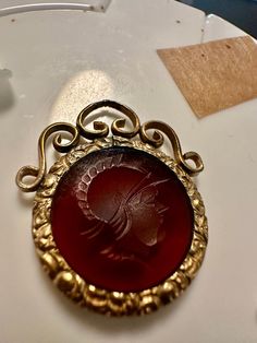 "Victorian goldfilled fob-intaglio carving of a warrior or ancient soldier or God, carved in a translucent brown glass-I added a ring for chain in one of the photos. Size 1 3/16\", wt.- 4.7 grams. Condition is good, any wear commensurate with age the photos show the details.  A wonderful necklace or bracelet charm from the 1800s." Ancient Etched Gold Jewelry, Collectible Etched Bronze Jewelry, Antique Intaglio Jewelry For Ceremonial Occasions, Vintage Coin Intaglio Jewelry, Antique Medallion Intaglio Jewelry, Antique Engraved Amber Jewelry, Vintage Intaglio Coin Jewelry, Antique Intaglio Pendant Jewelry, Ancient Soldier