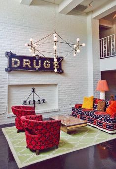 a living room filled with furniture next to a fire place and a white brick wall