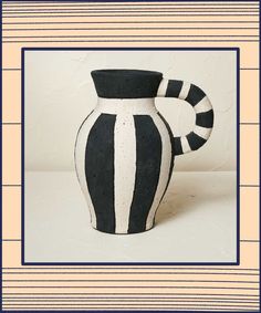 a black and white striped vase sitting on top of a table