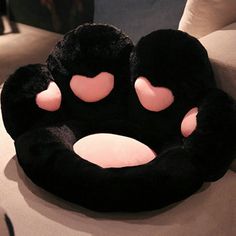 a black and pink animal pillow sitting on top of a couch