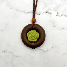 Squish Level: 8 Durability Level: 10 A fidget necklace meant to look like a succulent surrounded in dirt.  The cord has sliding knots so the length is adjustable. The longest length it can be adjusted to is about 32 inches, meaning it can hang down about 16 inches. You can twist the middle bead to fidget, or squish or chew on the pendent.  The entire pendent is made of a soft, smooth, food-grade silicone.  My fidget jewelry is for adults. Clean often with soap and warm water. Discard if the sili Adjustable Green Necklace For Everyday Use, Everyday Adjustable Green Necklace, Earthy Adjustable Round Pendant Necklace, Necklaces With Adjustable Cord And Flower Pendant, Adjustable Flower Pendant Necklaces With Cord, Adjustable Flower Pendant Necklaces With Adjustable Cord, Nature-inspired Adjustable Necklace For Everyday, Adjustable Earthy Pendant Necklaces, Brown Necklace With Sliding Knot For Gift