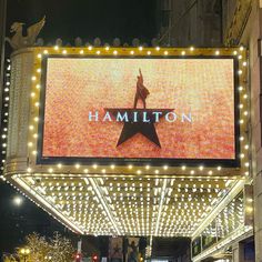 the marquee for the show is lit up with lights and people walking around