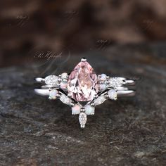 a pink diamond ring sitting on top of a rock