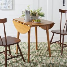 a small table with two chairs and a bowl of fruit on top of the table