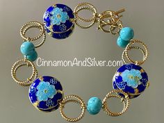 Blue Cloisonné and gemstone beaded bracelet adds a beautiful pop of summer boho color! Dark cobalt blue and bright turquoise colors are highlighted by metallic gold tones, with a fun circle and floral vintage boho motif! Bracelet is handmade from  twisted gold tone wire connecting rings, turquoise-dyed Howlite gemstone crystal beads, and cloisonné enamel coin beads.   Bracelet measures 8" long, but fits at 7.5" due to bead size. Can be lengthened by request. Closes with toggle clasp. Lead-free and nickel-free. Largest cloisonné bead is 1" diameter. Turquoise blue-dyed Howlite gemstone beads are 8mm. Cloisonné is an ancient enameling technique for decorating metalwork objects, with colored-glass paste placed within enclosures made of copper or bronze wires, which have been bent or hammered Blue Bangle Jewelry With Large Beads, Bohemian Blue Bracelets With Spacer Beads, Blue Bohemian Bracelets With Spacer Beads, Artisan Blue Bracelet As Gift, Artisan Blue Bracelet For Gift, Artisan Blue Bracelet Gift, Artisan Blue Bracelet Perfect For Gift, Artisan Blue Bangle Bracelet, Artisan Blue Bangle Bracelets