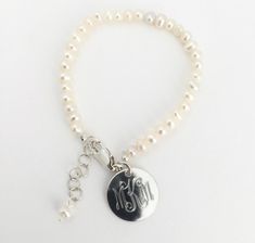 "Monogram Pearl Baby Bracelet Personalized, Monogram Freshwater Pearl Bracelet with Sterling Silver for Baby Gift Celebrate a new baby girl with this beautiful freshwater pearl bracelet with sterling silver tag and fittings. It includes a 1\" extender chain making it good for wearing as the baby grows into a toddler and little girl. . We will engrave a monogram or name onto the round pendant. Beautiful natural ivory color. Lobster Clasp. Comes in gift box. *Only for wear under supervision. Penda Personalized Adjustable Classic Pearl Bracelet, Classic Personalized Adjustable Pearl Bracelet, Classic Adjustable Personalized Pearl Bracelet, Personalized Classic Pearl Bracelet, Classic Personalized Pearl Bracelet, Classic Personalized White Pearl Bracelet, Silver Pearl Bracelet With Pearl Charm For Mother's Day, White Engraved Round Bracelets, Personalized Silver Pearl Bracelet For Birthday