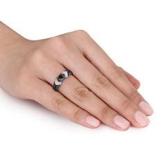 a woman's hand wearing a ring with a black stone on it and a white background