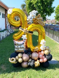 a large balloon shaped like the number 50 with balloons and flowers on it in front of a house