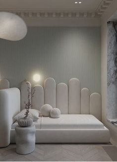 a white bed sitting in the middle of a room next to a wall with lights on it