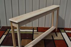 a wooden bench sitting on top of a rug