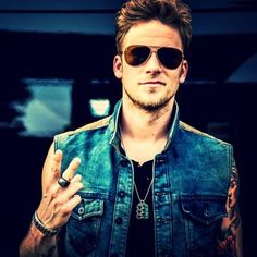 a man wearing sunglasses and a denim vest