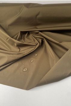 Khaki Tone- Waterproof Twill Fabric. Haute Couture French Designer Brand.  This weighty fabric has a luxurious feel and drape. It is a non-stretch type and fully waterproof, ideal for raincoats and trench coats. It comes directly from the design house of a very famous luxury French designer brand.  Composition: Polyamide Density- 140.00 g/m² Width- 145.00 cm Purpose- Raincoat, Trench Coat Weaving- Twill Stretch- Non-stretch Color- Shade of green All fabrics are portrayed in a natural light. If you require additional images and videos, please message us. Trench Coat Fabric, Waterproof Khaki Nylon Raincoat, Khaki Nylon Waterproof Raincoat, Khaki Waterproof Nylon Raincoat, Waterproof Khaki Raincoat For Rainy Weather, Types Of Clothes Fabrics, Raincoat Trench, French Haute Couture, Haute Couture Fabric