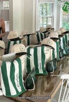 several hats and purses are lined up on a table in front of a window