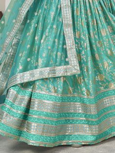 Introducing our captivating sea green zari embroidered jacquard lehenga choli, a stunning ensemble that is sure to make you stand out at any wedding or special occasion. This beautiful lehenga features intricate zari embroidered work and sequin embellishments, adding a touch of glamour and elegance to your look.
The sea green color of the lehenga is absolutely mesmerizing, creating a striking and eye-catching appearance. The jacquard fabric adds a luxurious touch to the outfit, giving it a rich Green Dola Silk Sets With Self Design, Festive Turquoise Sharara With Resham Embroidery, Green Self Design Sets In Dola Silk, Designer Turquoise Lehenga With Dupatta, Green Unstitched Lehenga With Intricate Embroidery, Unstitched Green Lehenga With Intricate Embroidery, Green Banarasi Silk Sharara For Wedding, Festive Turquoise Anarkali Set With Resham Embroidery, Designer Green Brocade Traditional Wear