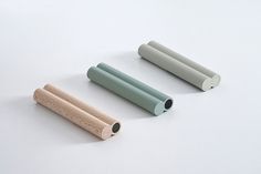 three different colored rolling rollers on a white surface