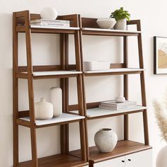 a wooden shelf with books and vases on it