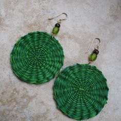 These are vibrant green earrings made with iraca fiber. Iraca is lovely and lightweight. Iraca fiber - The discs are hand woven, and no two are exactly the same. Source: Fallen leaves from Iraca palm plants in South America. Color: Two shades of green Iraca disc diameter: 2 inches  Accent beads: Green frosted glass and wood Earring length: 3 inches Ear wire: 14k gold-filled Bohemian Green Circular Earrings, Green Bohemian Circle Earrings, Beach Woven Green Jewelry, Round Woven Earrings, Round Woven Earrings For Gift, Woven Round Earrings Perfect For Gifts, Round Woven Earrings Ideal For Gifts, Artisan Green Drop Earrings, Green Bohemian Woven Earrings