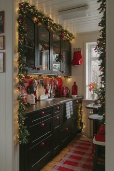 a kitchen decorated for christmas with garland and lights