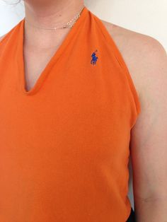 This reworked vintage Ralph Lauren orange halter top is perfect for the summer! Cropped below the belly button, this shirt is backless so you can perfect your glowing tan while looking glamorous *and* being environmentally friendly by shopping vintage! What better combination could there be?  ONLY ONE. UTTERLY UNIQUE. Length from shoulder to hem: 17 inches Fitted V-neck Tops For Beach Season, Orange Short Sleeve Crop Top For Summer, Orange Halter Neck Tank Top For Spring, Fitted Backless Tops For Beachwear, Retro Sleeveless Halter Top For Summer, Orange Beachwear Tops For Beach Season, Casual Orange Sleeveless Halter Top, Fitted Orange Halter Top, Fitted Orange Halter Neck Top