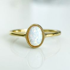 A dreamy and romantic opal ring featuring a round cut in a bezel setting and an elegant polished band in 14K gold plating over sterling silver.
A delicate vintage design and a glowing opal stone make this a truly unique piece. Vintage Wedding Rings Opal, Big Opal Ring, Anniversary Opal Ring Stamped 14k In Oval Shape, Stackable Oval 14k Gold Jewelry, Elegant Stackable Ring Jewelry, Classic Oval Stackable Jewelry, Classic Stackable Jewelry For Promise Ring, Heirloom Stackable White Jewelry, Yellow Gold Stackable Oval Jewelry