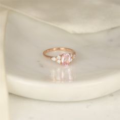 If you fancy peach sapphire rings, Thea is your gal! she is a one of a kind cluster ring that you can only find here at Rosados Box. #rings #engagementrings #weddingrings #rosadosbox #selftreat #rosegold #blush #champagne #sapphire #peach #gemstone #diamonds #cluster #oval #jewelry #finejewelry #gifts #sparkle #jewelry #finejewelry #gifts Rose Gold Oval Sapphire Ring With Brilliant Cut, Classic Morganite Diamond Ring For Wedding, Classic Morganite Diamond Wedding Ring, Morganite Pear-shaped Wedding Rings, Pear-shaped Morganite Wedding Jewelry, Classic Oval Morganite Diamond Ring, Pear-shaped Morganite Wedding Ring, Gia Certified Rose Gold Wedding Diamond Ring, Rose Gold Sapphire Ring With Diamond, Oval Cut