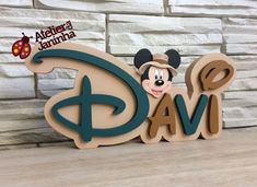 a wooden name sign with mickey mouse on it's face and ladybug