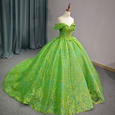 a green ball gown is displayed on a mannequin