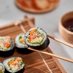 sushi rolls with chopsticks on a bamboo mat