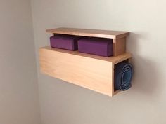 a wooden shelf with purple yoga mats on it