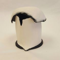 a white and black hat with snow on top