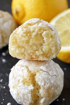 three lemon cookies stacked on top of each other next to lemons and powdered sugar