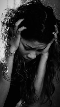 black and white photograph of a woman holding her head