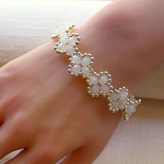 About this item-- Elevate your style with this delicate four-leaf clover bracelet, crafted with exquisite milky white crystals and silver seed beads. It features a matching silver-colored toggle clasp for a secure and stylish closure, all woven together with super-strong, micro-fused braided thread. Perfect for any occasion, this bracelet is a must-have addition to your jewelry collection! One-of-a-kind piece available in only one size. Please take a moment to check the measurements to ensure a perfect fit. Specs-- Measurement: length - 190 mm (7.5 inches) width - 17 mm (0.66 inches) Material: crystal, Japanese galvanized silver (plated) bead, micro-fused braided thread Color: white, silver Hardware: toggle clasp Weight: 20 grams Production ID: BR051 Elegant Beaded Flower-shaped Jewelry, Handmade Dainty Pearl White Bracelets, Handmade White Crystal Bracelet With Flower Shape, Handmade White Crystal Bracelet In Flower Shape, Handmade White Crystal Flower Bracelet, Elegant White Crystal Bracelet With Spacer Beads, White Delicate Beaded Bracelet, Delicate White Adjustable Crystal Bracelet, White Flower-shaped Wedding Bracelets