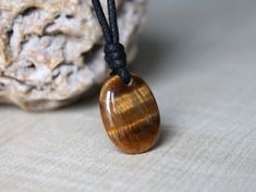 "Tigers Eye stone on adjustable cord. This beautiful Tigers Eye necklace is a perfect idea for gift. - MATERIAL - natural Tigers Eye. Size stone: 23 x 17 x 6 mm (0.9\"x 0.67\"x 0.24\"). - CORD - 1,5mm Black Polyester Cord or 1,5mm Black Wax Cotton Cord (Please select the cord of your choice from the drop down menu). On the PHOTO Tigers Eye with Wax Cotton Cord! Cord length is adjusted by sliding knots from 14 up to 28 inches (35.6 to 71 cm) or 16 up to 32 inches (40.6 to 81 cm). Please select the cord length from the drop down menu. Please be aware that it is handmade, so it can be inaccuracy of the size - 0.5 inches shorter or longer. You can wear it as a long necklace or a shorter one. ~ ~ ~ ~ ~ ~ ~ ~ ~ ~ ~ ~ ~ ~ ~ ~ ~ ~ ~ ~ ~ ~ ~ ~ ~ ~ ~ ~ ~ ~ ~ ~ ~  Tiger's eye is a very protective sto Tiger Eye Necklace, Tigers Eye Necklace, Protection Necklace, Eye Pendant, Tiger Eye Stone, Eye Stone, Tigers Eye, Girlfriend Boyfriend, Eye Necklace