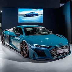 a blue sports car is on display in a showroom