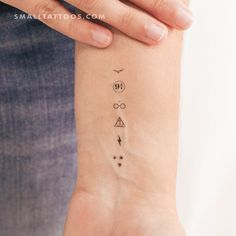 a person with a tattoo on their wrist that has three symbols and stars in it