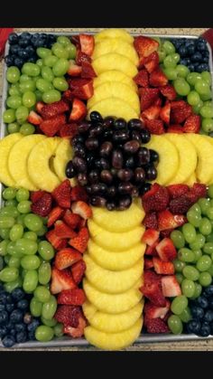 a cross made out of fruits and grapes