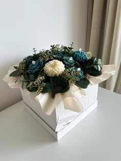 a white box filled with flowers on top of a table