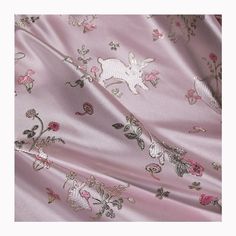 a pink fabric with flowers and animals on it, as seen from the bottom view