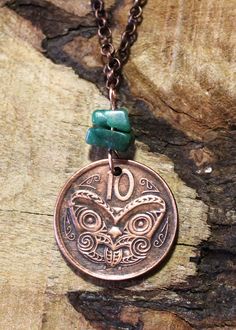 Maori Mask Coin Necklace - Malachite Gemstone Beads - New Zealand  This necklace was made from a genuine coin from New Zealand. The coin features a Maori carved 'Koruru' or Gable Mask. A small hole was drilled to attach 2 lovely Malachite gemstone beads to the pendant and a 60cm antique copper coloured link chain. The coin has  been cleaned, antiqued and highlighted. The coin is approx. 2.0cm in diameter.  All chains or necklaces are interchangeable. If you don't like the necklace we have chosen Coin Necklace, Copper Color, Antique Copper, Charm Necklace, Gemstone Beads, Copper, Mask, Jewelry Necklaces, Etsy Accessories