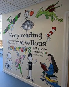 a wall painted with children's books and cartoon characters is shown in the hallway