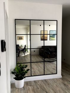 a large mirror is reflecting the living room and dining room in this modern style home