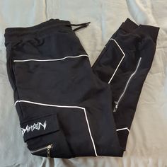 Black Joggers With Flap Cargo Pockets And Drawstring Waist. Reflective Piping And Zip Details. Approx 27" Inseam. Nwot From A Smoke-Free Home. Black Gothic Bottoms For Streetwear, Gothic Cotton Bottoms For Streetwear, Gothic Cotton Streetwear Bottoms, Hip Hop Black Bottoms For Concert, Casual Black Pants For Concert, Fitted Black Pants For Streetwear, Gothic Bottoms With Cargo Pockets For Streetwear, Gothic Bottoms With Pockets For Streetwear, Gothic Streetwear Bottoms With Pockets