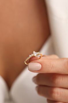 a woman's hand holding a diamond ring