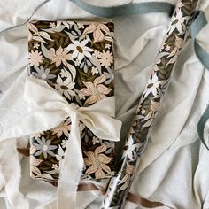 a white and black flowered cloth with a bow on it's end, next to a pair of scissors