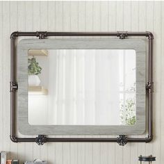 a bathroom mirror sitting on top of a wooden shelf