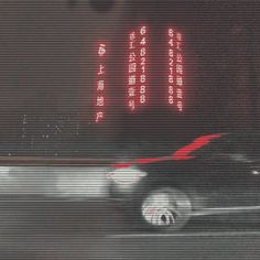 a blurry image of a car driving down the street with chinese writing on it