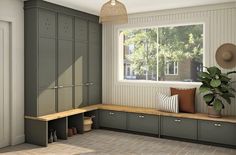 a room with some gray cabinets and a potted plant on the window sill