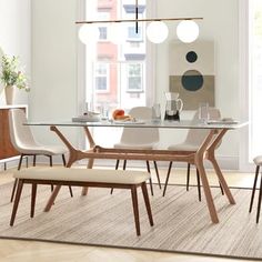 a dining room table with chairs and a bench in front of the glass top table